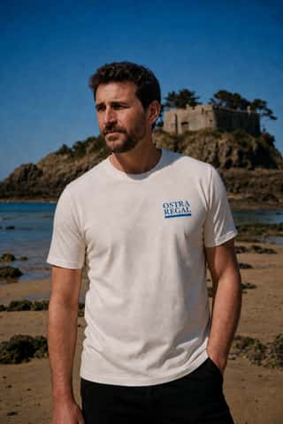 T-shirt Ostra Regal porté, le sigle de la maison sur le cœur, plage du Fort du Guesclin